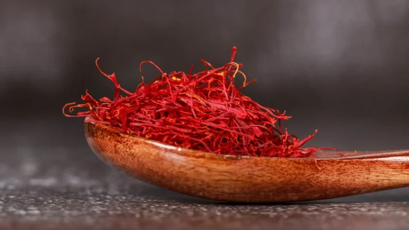 kashmiri saffron in a wooden spoon on a table